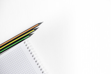 Spiral notebooks and simple pencils are highlighted on a white background for the layout on the left side, on the right side there is space for text