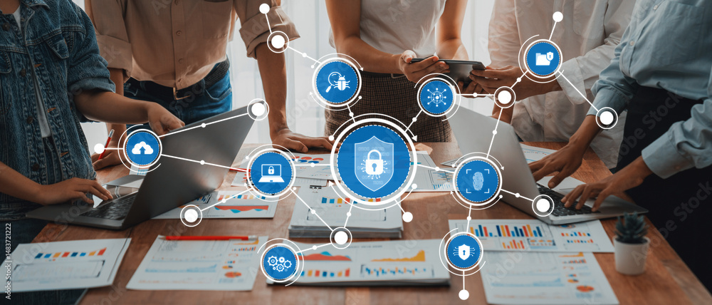 Fototapete A dynamic team engages in discussions around security solutions, utilizing laptops and data charts to drive innovation and collaboration in a modern office environment. Amity