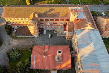 Aerial view of an old factory with large windows and vintage industrial architecture, showcasing...