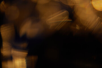 Abstract light leaks on black background with copy space. Studio lens flare bokeh effect.