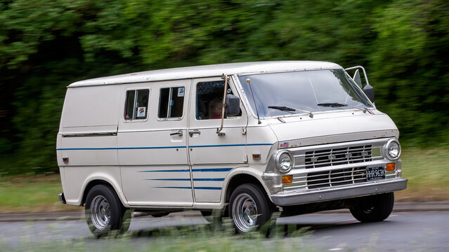 Milton Keynes,UK - May 15th 2025:  1972 Ford Econoline van classic car driving on a British road.