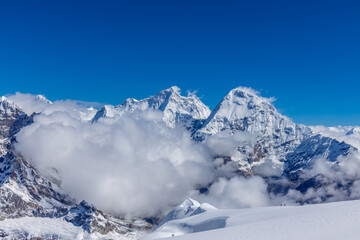 Mera Peak high altitude mountain summit ascent in Himalayas. Stunning views above the clouds at sunrise from the top of the mountain. Alpine route climbing on the snow path in Himalayas