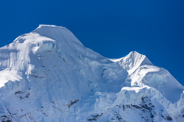 Mera Peak high altitude mountain summit ascent in Himalayas. Stunning views above the clouds at sunrise from the top of the mountain. Alpine route climbing on the snow path in Himalayas