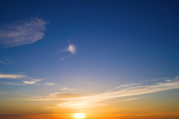 Orange blue sky background with dark clouds at sunset on a summer evening