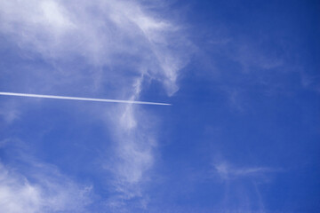Blue sky background with flying airplane on sunny day
