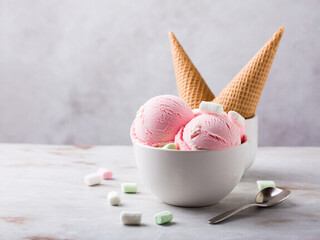 Top view of ice cream in bowl on marble table with marshmallows and empty cones