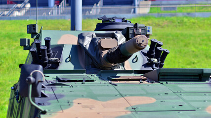 Heavy military tank vehicle turret gun aiming on a target and ready to fire. The rotating turret barrel tip of a tank. Detail shot with the  turret barrel tip of a modern tank. © Grand Warszawski