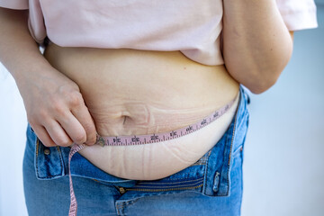 Fat belly in jeans, Chubby woman checking waistline, self check, real life, midlife crisis, home...