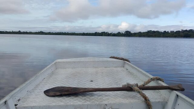 POV sailing in speedboat or canoe through the flooded forest in Amazon River. Front view of boat crossing igap&oacute;s, lake stream, sea, ocean. Kayaking in the jungle, rainforest. Paddle and rope in dock.