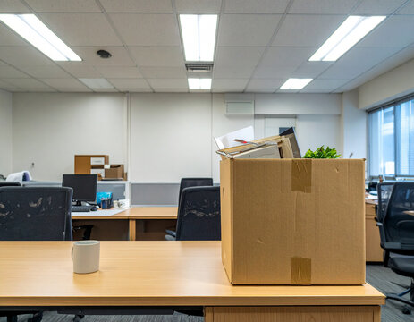 Abandoned office space and items like cardboard boxes or empty chairs, depicting resignation or job transition themes.