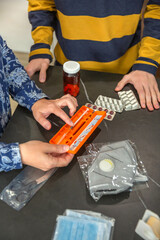 Unrecognizable mother showing how to use medical injection with pre filled syringe to son while...
