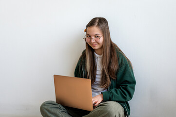 Teenage student holding a laptop on white background