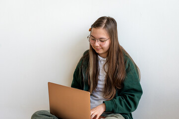 Naklejka premium Teenage student holding a laptop on white background