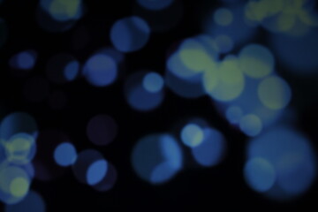 Christmas lights in bokeh. Outside in December. Snow and blue bokeh on a black background, bokeh abstract background, modern technological abstract background. Blue Christmas background, Xmas bokeh 
