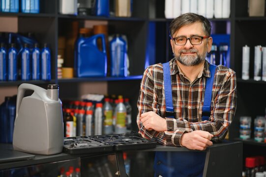 Salesman smiling in auto parts store with motor oil and tools