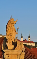 Statuen der Karlsbrücke in Prag mit Strahov Abtei im Hintergrund, vertikal