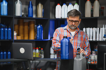 Salesman scanning engine oil in auto parts store