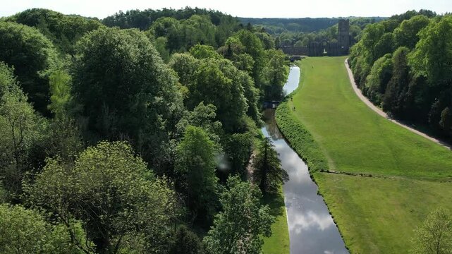 RIPON, YORKSHIRE/UK - May 11, 2025: The ruins of Fountains Abbey on a fine spring day  as viewed from across the river Skell near Ripon, Fountains Abbey and Studley Royal Water Garden Yorkshire, UK.