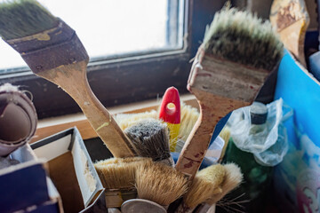 Collection of used paintbrushes in a box, Various sized and dirty paintbrushes close-up.