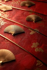 Golden folding fans on a red texture background with floral accents