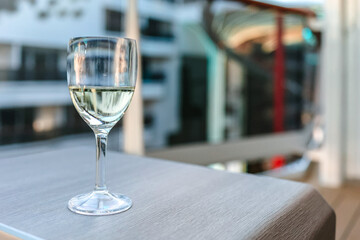Glass of white wine on table in sunlight. Atmosphere of delightful event