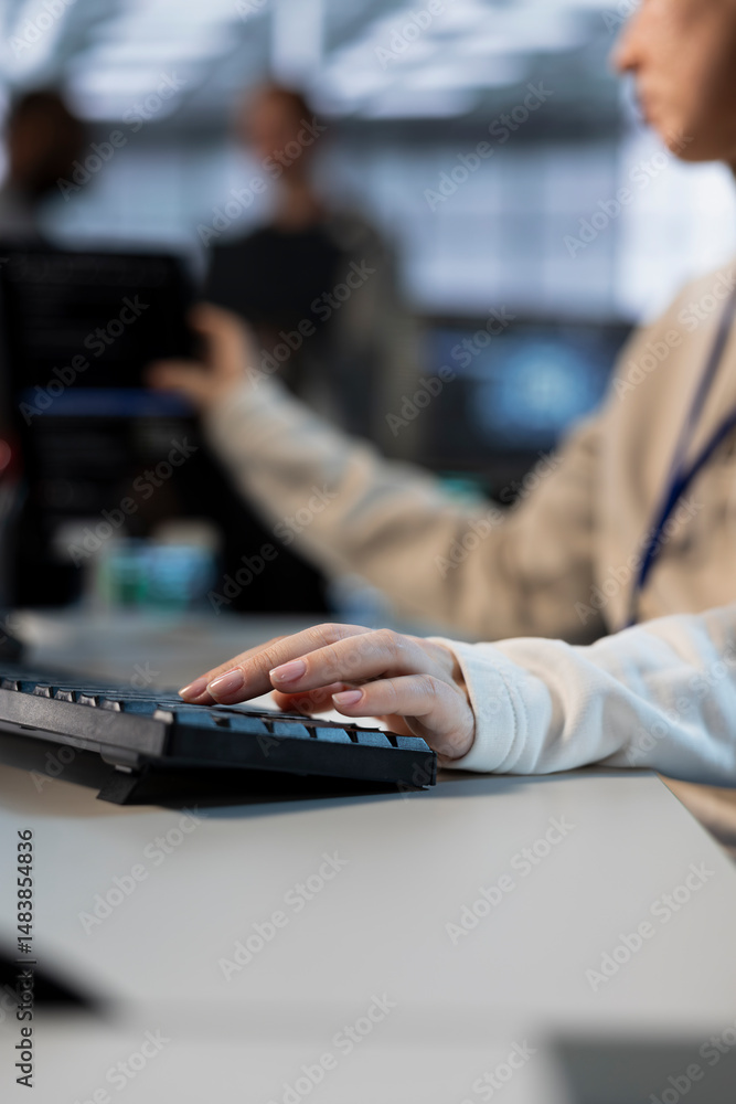 Poster technician in server room typing on keyboard, implementing power management solutions to reduce ener