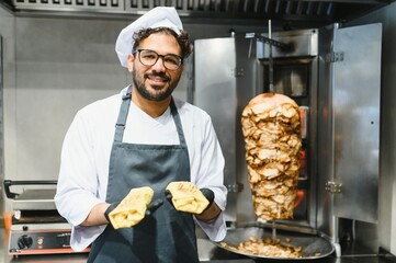 Chef holding shawarma wraps in a street food restaurant