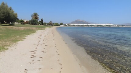 Obraz premium Scenic Coastal Beach Landscape with Calm Sea and Mountain View