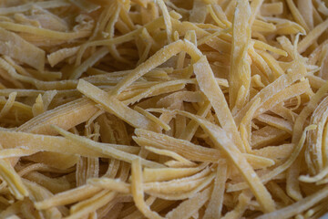 Close-Up of Fresh Homemade Tagliatelle Pasta with Rustic Texture and Flour Dusting