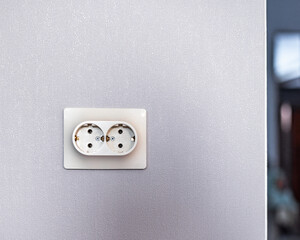 Double electrical outlet on a gray wall, renovation and construction