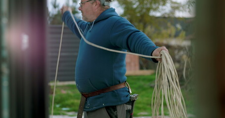 Carrying and organizing cables at construction site by worker with helmet, showcasing manual labor...