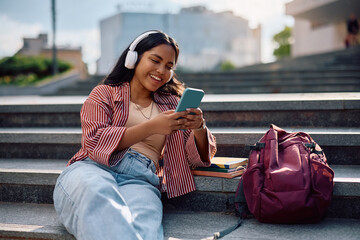 Fototapeta na wymiar Happy Indian student using her smart phone at university campus.