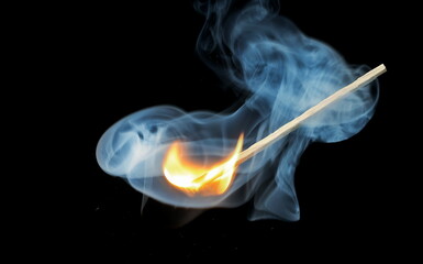Matchstick ignite burning bright fire flame and smoke isolated on black, clipping
