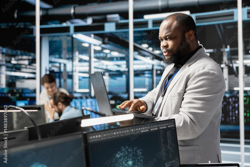 Poster data center admin using laptop to update servers tech, configuring gear using software. server farm 