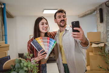 Self portrait of couple hold color palette and choose new wall color