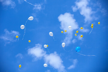 A bunch of balloons are floating in the sky