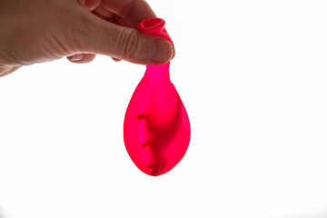 Deflated balloon with plastic dinosaur inside held in child hand part of freezing experiment for home learning kits, workshops, social media crafts, and playful brand content