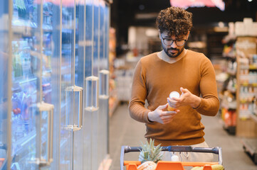 Customer reading product label while shopping in supermarket