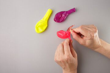 Inserting small dinosaur into balloon during DIY frozen egg craft for kids, suitable for toy shops, teaching content, science kits, creative learning visuals, hands-on education resources,