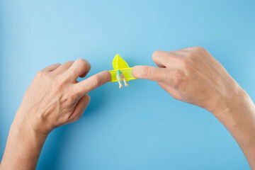 Hands inserting small dinosaur toy into balloon, part of frozen egg DIY activity for kids, suitable for science content creators, educational materials, toy shops, parenting guides, teaching visuals,