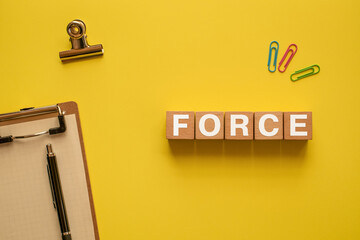 There is wood cube with the word FORCE. It is as an eye-catching image.
