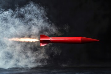 A red rocket flying with smoke and fire against a dark background in a horizontal shot