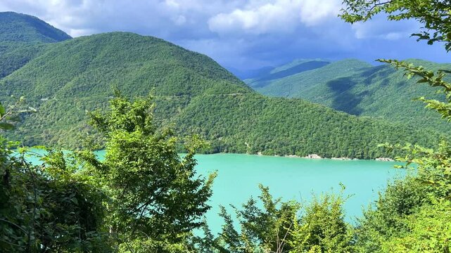 The Zhinvali reservoir, the lake landscape with mountains, the main Caucasian ridge, the Georgian military road. Georgia. An artificial reservoir. Blue sky with white clouds. 4К