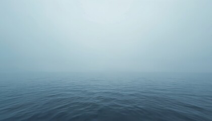 Obraz premium Misty ocean horizon. Calm blue water surface. Fog and mist create moody, serene atmosphere. Minimalist, abstract marine landscape reflects quiet environment. Peaceful, tranquil scene.