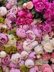 colorful assortment pink and white flowers fills display, featuring peonies, roses, and other blooms arranged artfully. vibrant colors and textures create stunning visual impact. close up.