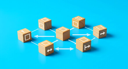 Seven wooden blocks with white symbols connected by arrows on a bright blue background studio shot