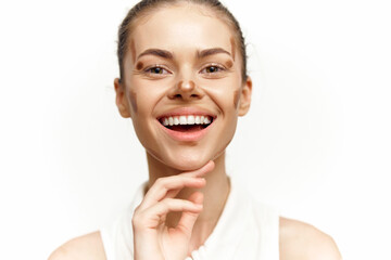 Fototapeta premium Smiling young woman with natural makeup, white background, showcasing confidence and happiness in a minimalistic style ideal for beauty and wellness concepts.