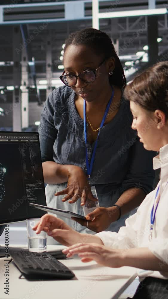 Poster vertical video cheerful data center engineers doing fist bump after completing successful ai system 