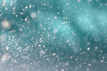 Obraz premium Snowfall against a blurred teal background.