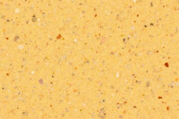 Textured yellow sand background with scattered granules and speckles  